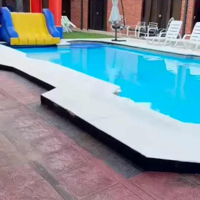 Pileta del complejo con reposeras y el tobogán inflable al costado